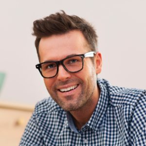 Smiling man wearing glasses and checked shirt